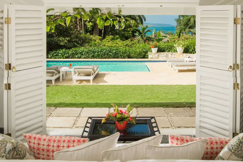 Living room doors opening to a private pool at Round Hill Hotel And Villas.