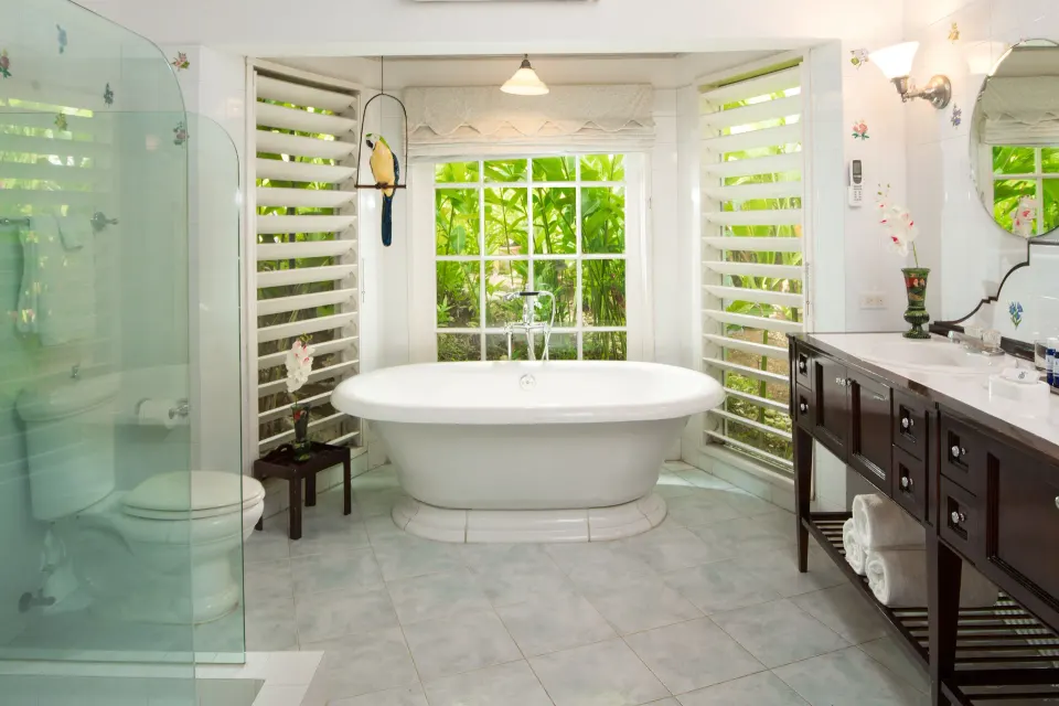 Freestanding tub and glass shower in a classic villa bathroom at Round Hill Hotel And Villas.