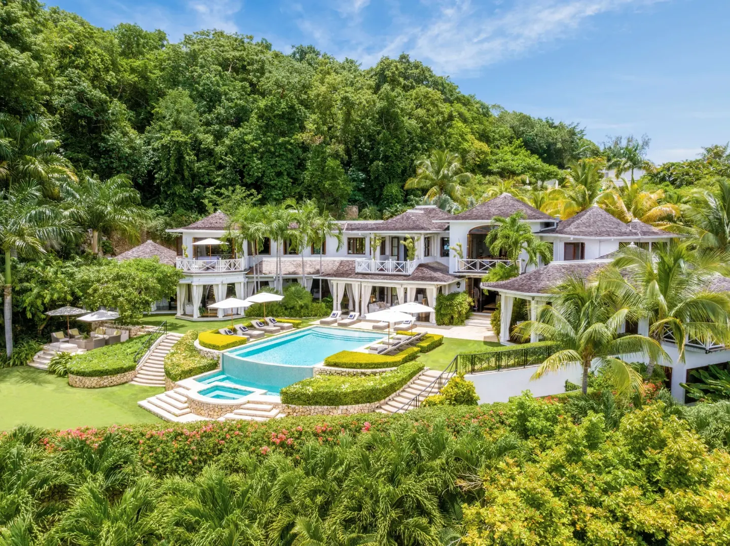 Estate Villa 5 Bedroom exterior with pool and tropical hillside at Round Hill Hotel And Villas.