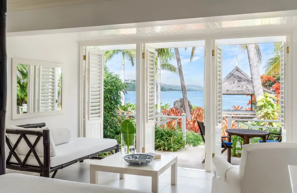 Oceanfront Premium Room seating area and balcony view at Round Hill Hotel And Villas.