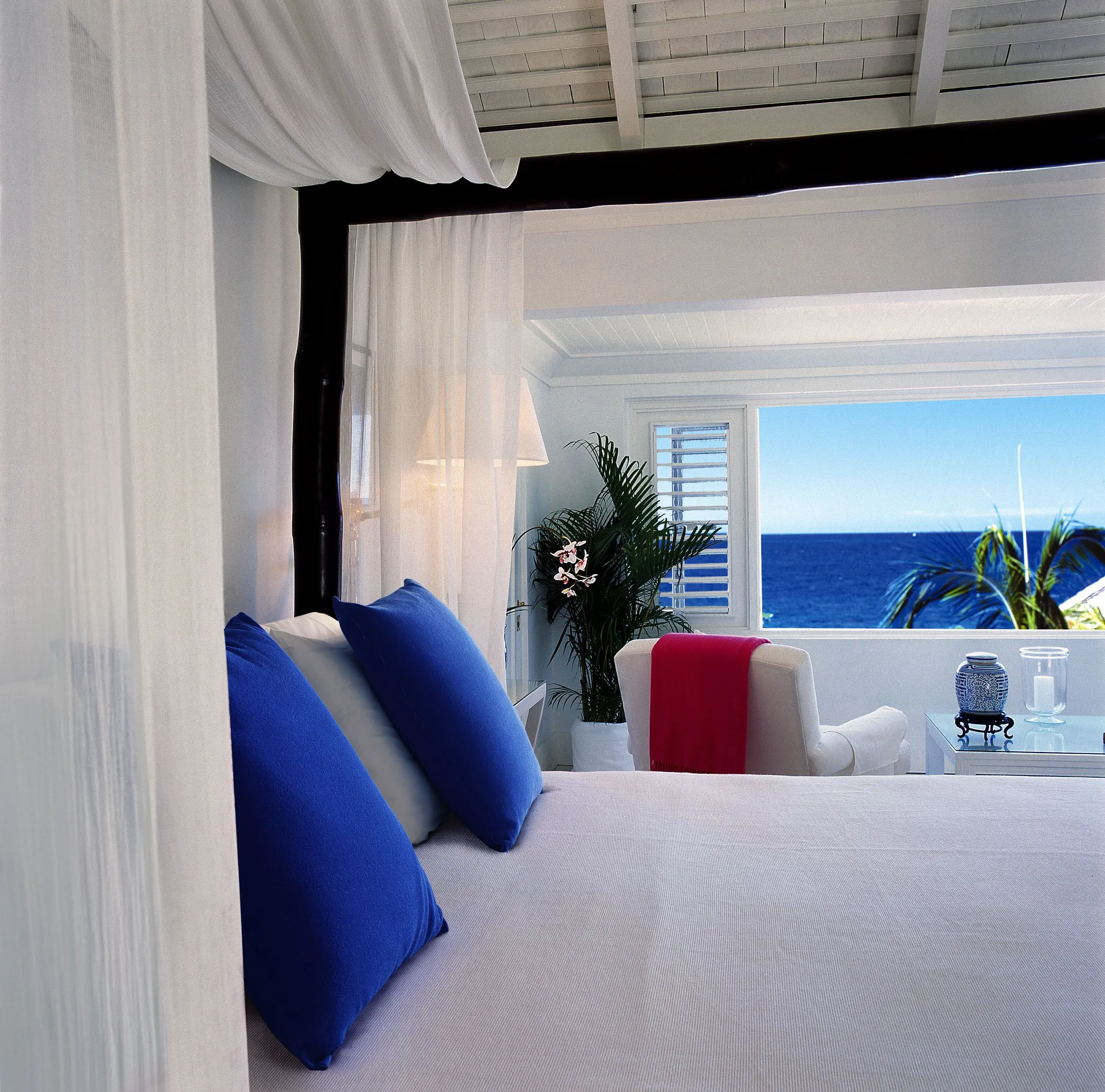 Premium Room Ocean View at Round Hill Hotel And Villas featuring elegant canopy bed with sweeping Caribbean Sea views from Montego Bay.