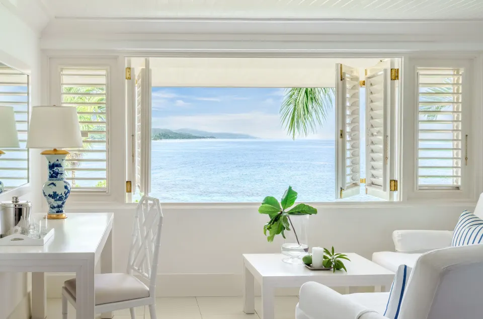 Premium Room Ocean View sitting area with open shutters at Round Hill Hotel And Villas.
