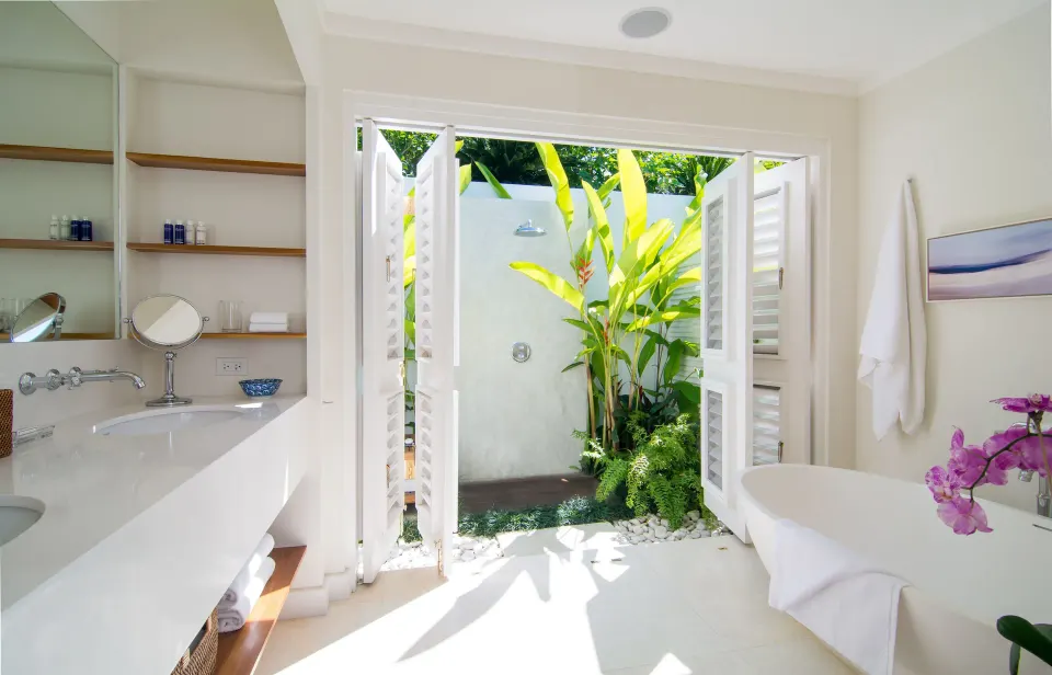 Villa bathroom opening to an outdoor shower garden at Round Hill Hotel And Villas.
