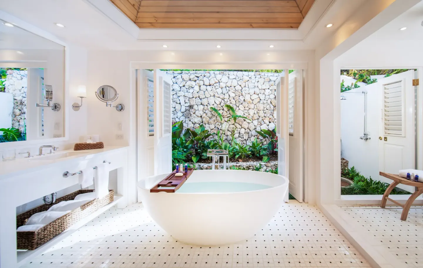 Signature Villa bathroom at Round Hill Hotel And Villas with freestanding tub, vanity, and garden shower area.