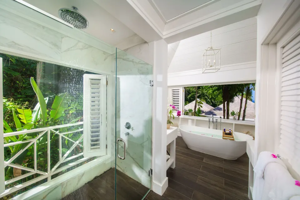 Bathroom with glass shower and freestanding tub at Round Hill Hotel And Villas.