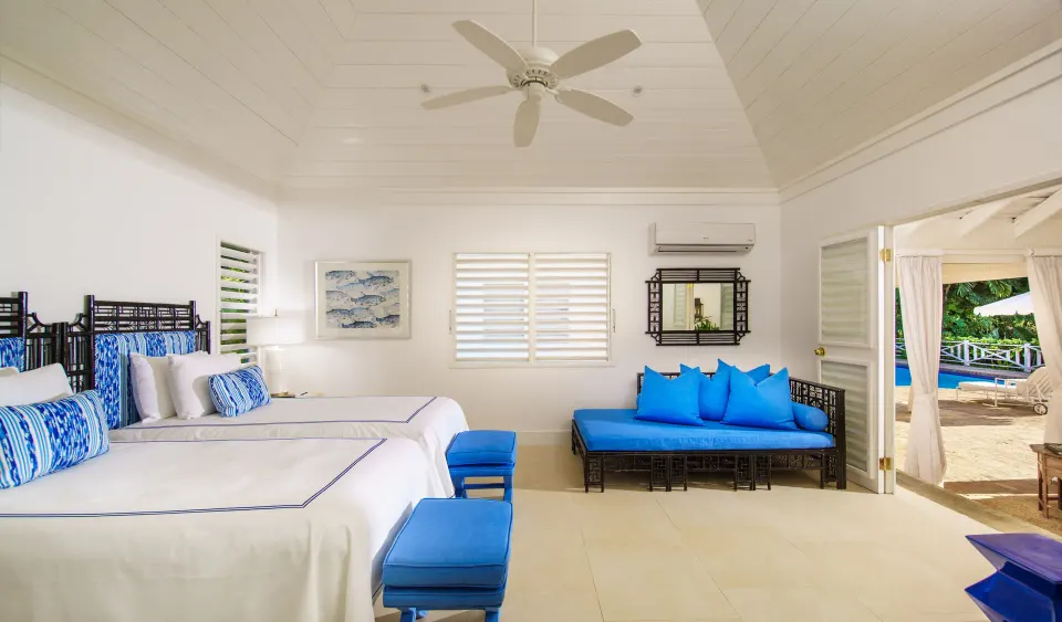 Guest room with two beds and blue seating at Round Hill Hotel And Villas.