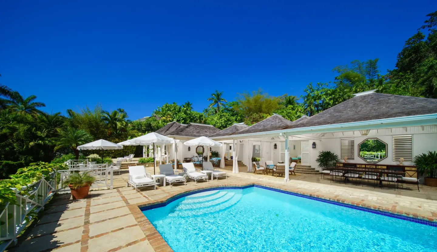 Private villa pool with loungers and white umbrellas at Round Hill Hotel And Villas.