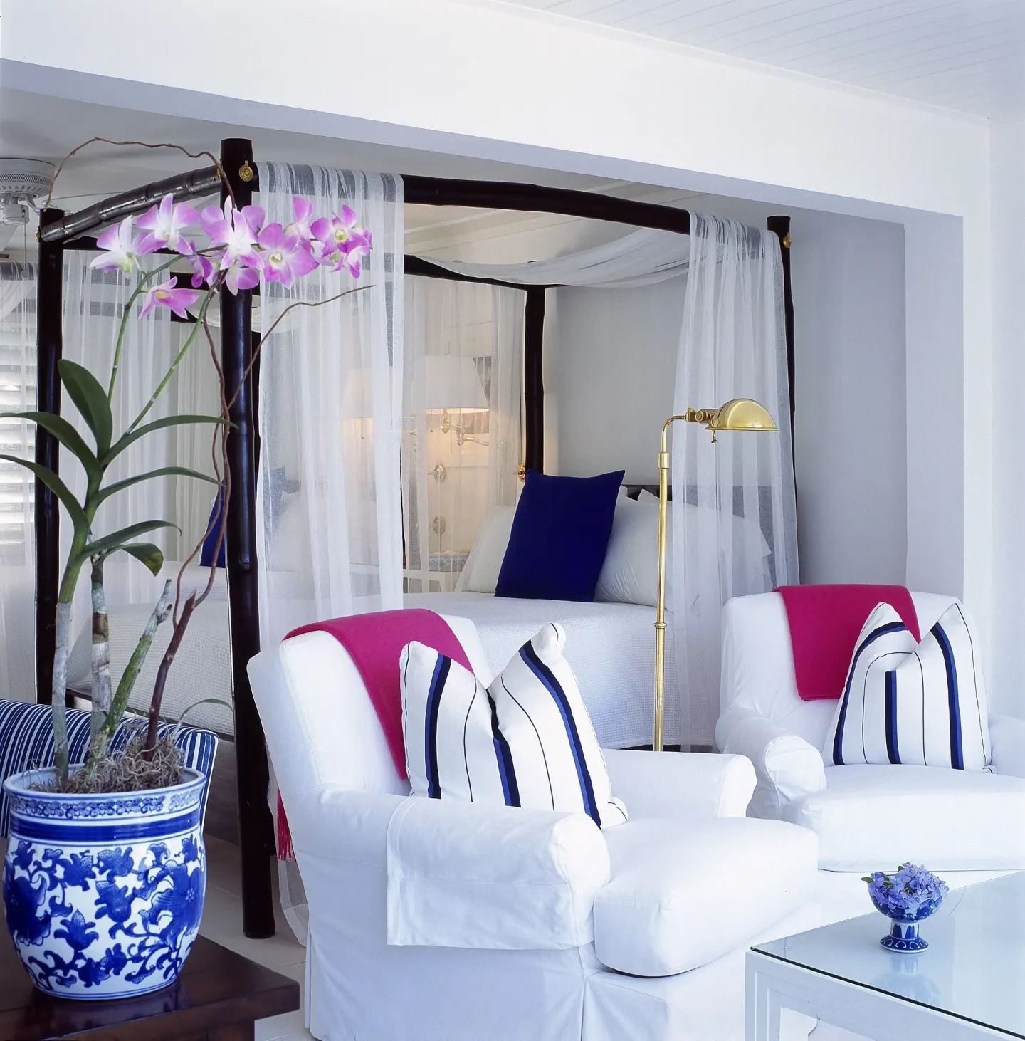 Standard Oceanfront Room seating and four-poster bed at Round Hill Hotel And Villas.