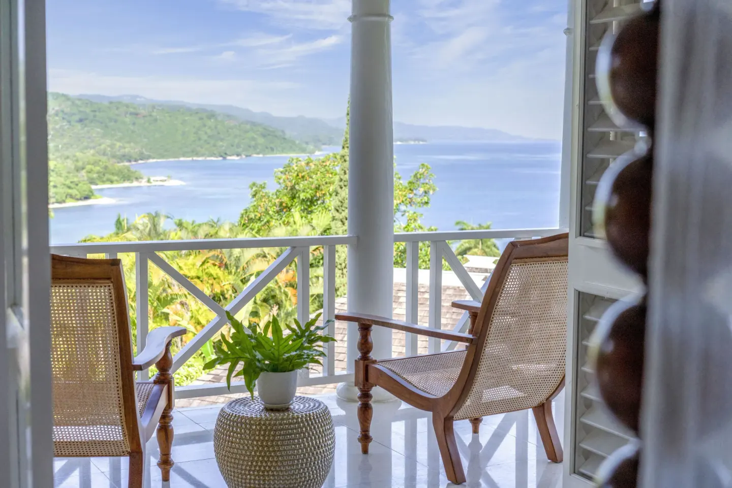 Ocean view balcony with cane chairs at Round Hill Hotel And Villas.