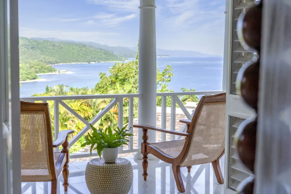 Ocean view balcony with cane chairs at Round Hill Hotel And Villas.