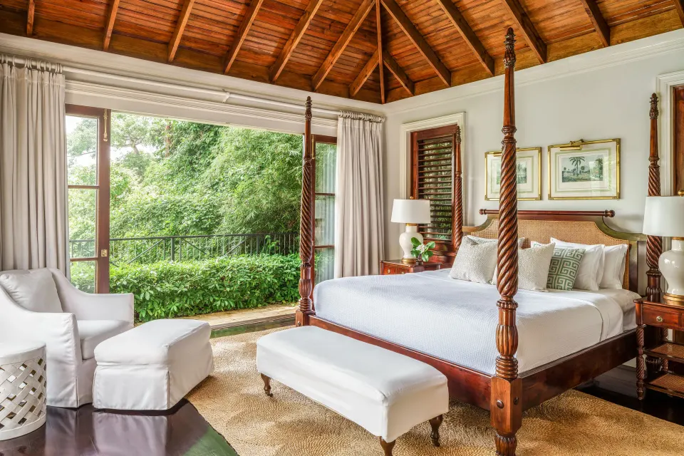 Four-poster bed beneath a wood ceiling in a suite at Round Hill Hotel And Villas.