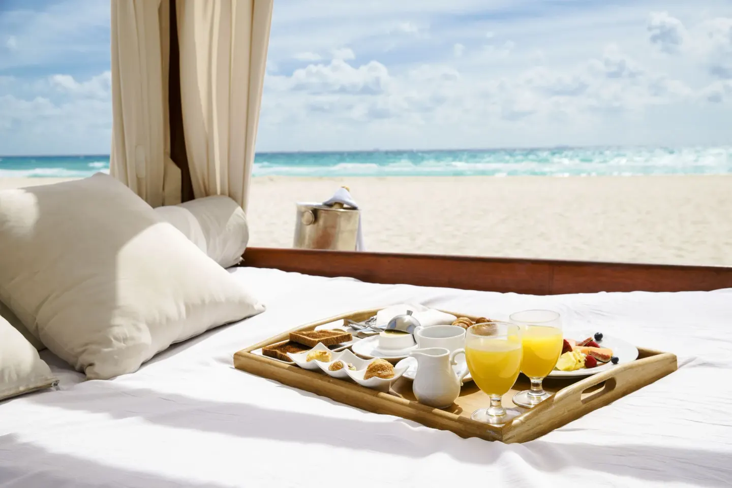 Breakfast tray on a beach cabana bed at Royal Hideaway Playacar.