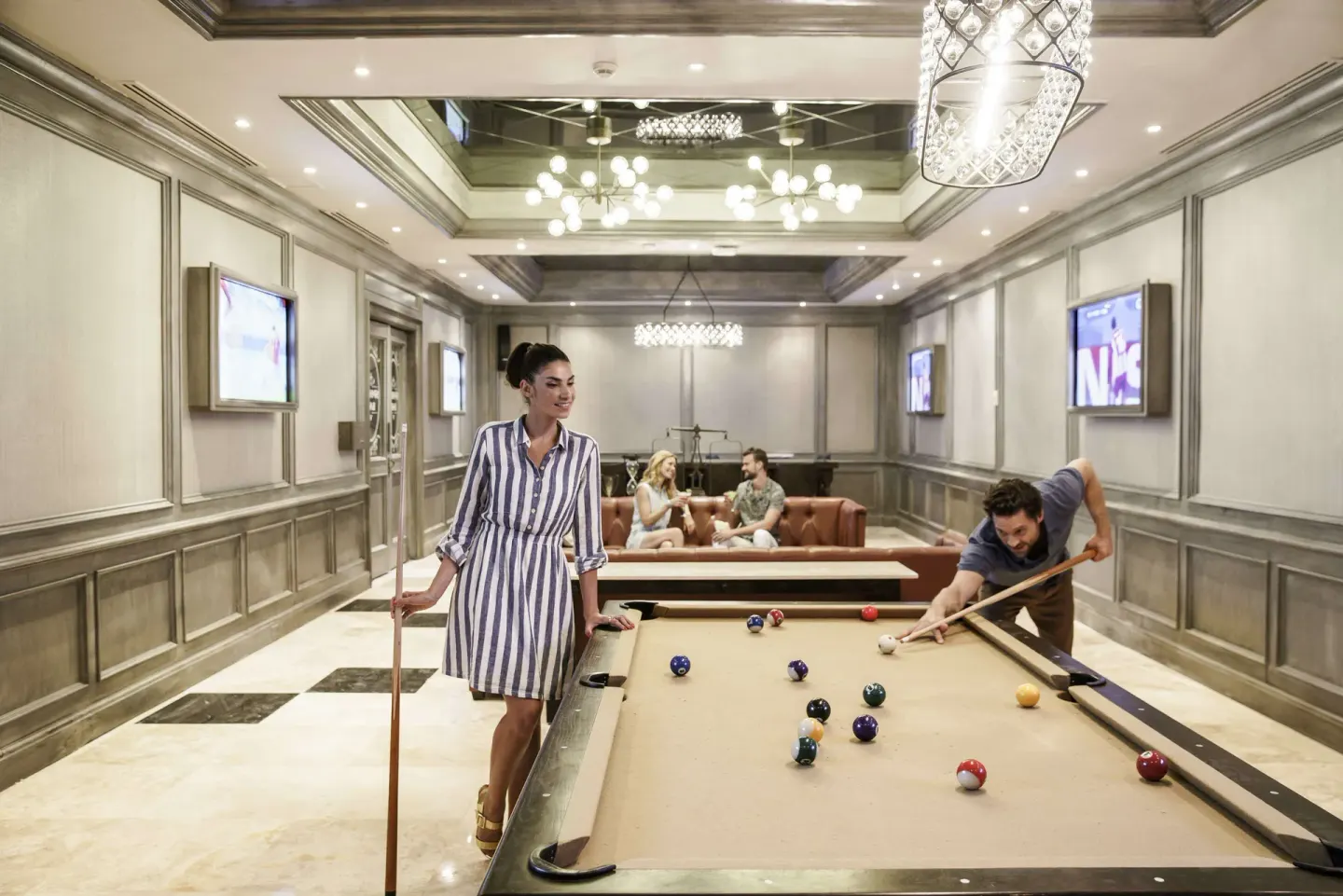 Guests playing pool in an indoor lounge at Royal Hideaway Playacar.