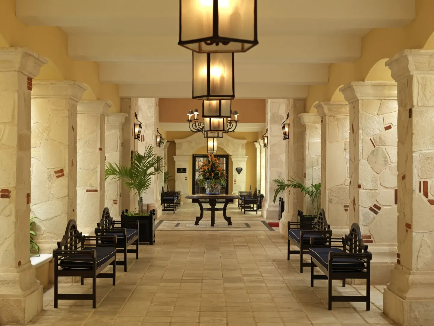 Columned lobby corridor with benches and lanterns at Royal Hideaway Playacar.