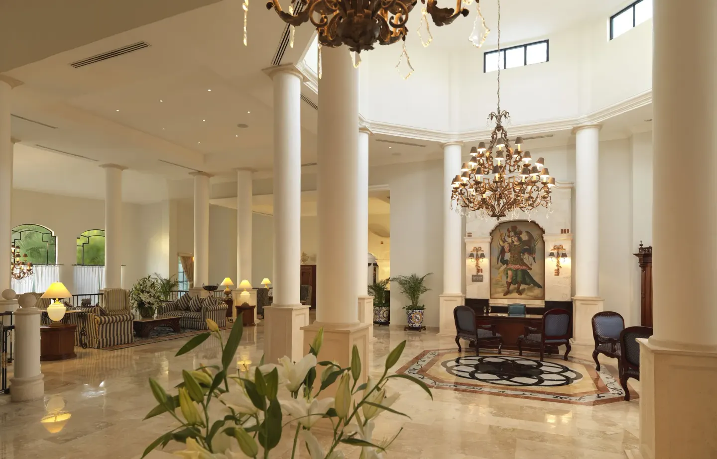Grand lobby with white columns and chandeliers at Royal Hideaway Playacar.