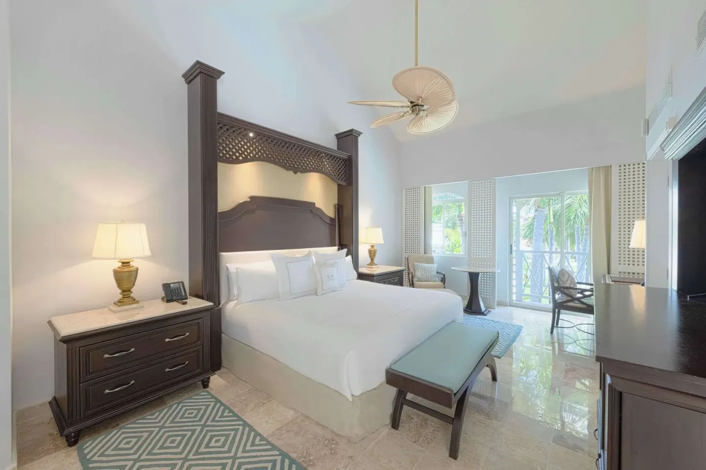 Guest room king bed with balcony doors and dark wood furniture at Royal Hideaway Playacar.