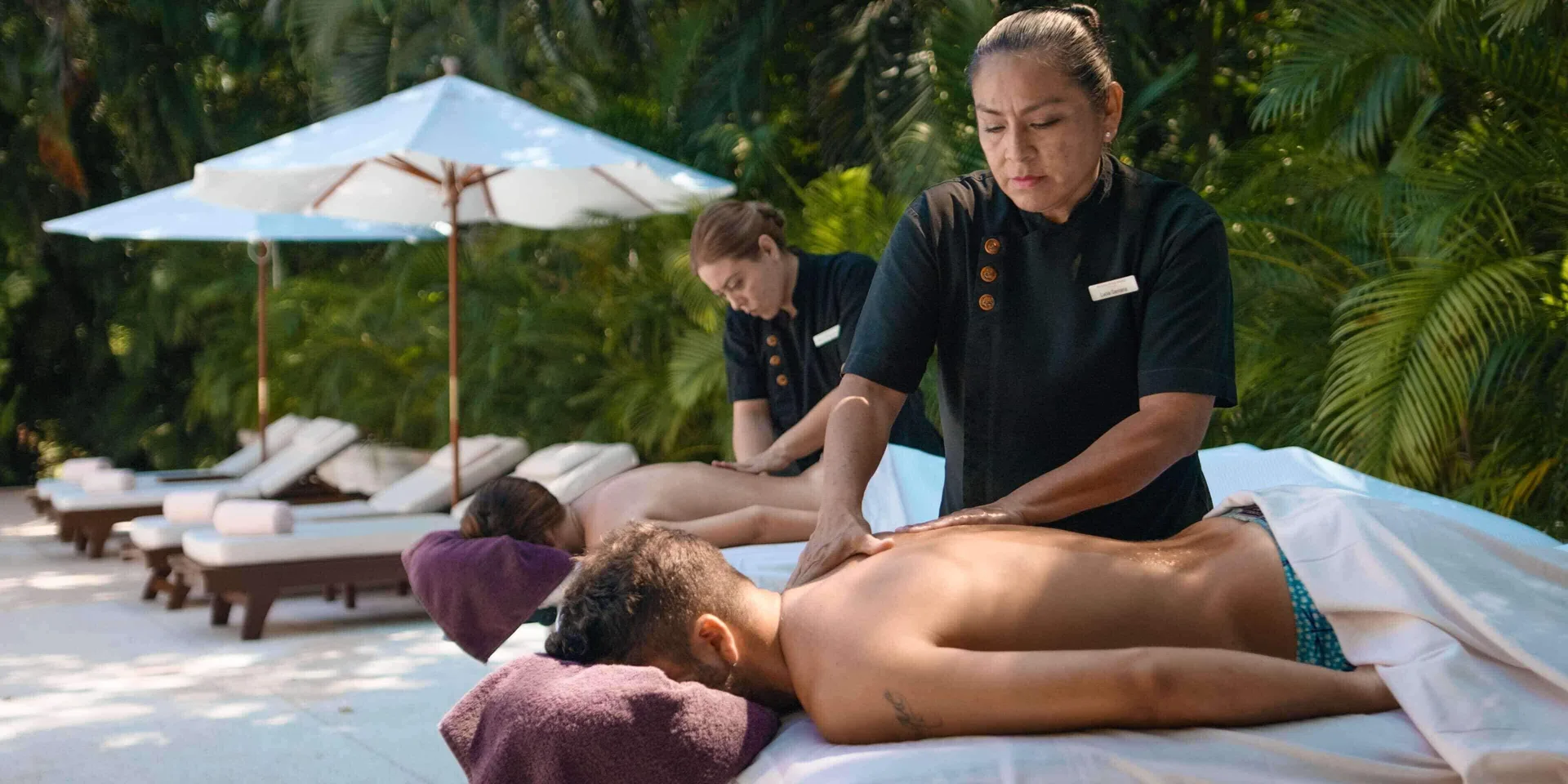 Outdoor couples massage beside tropical greenery at Royal Hideaway Playacar.