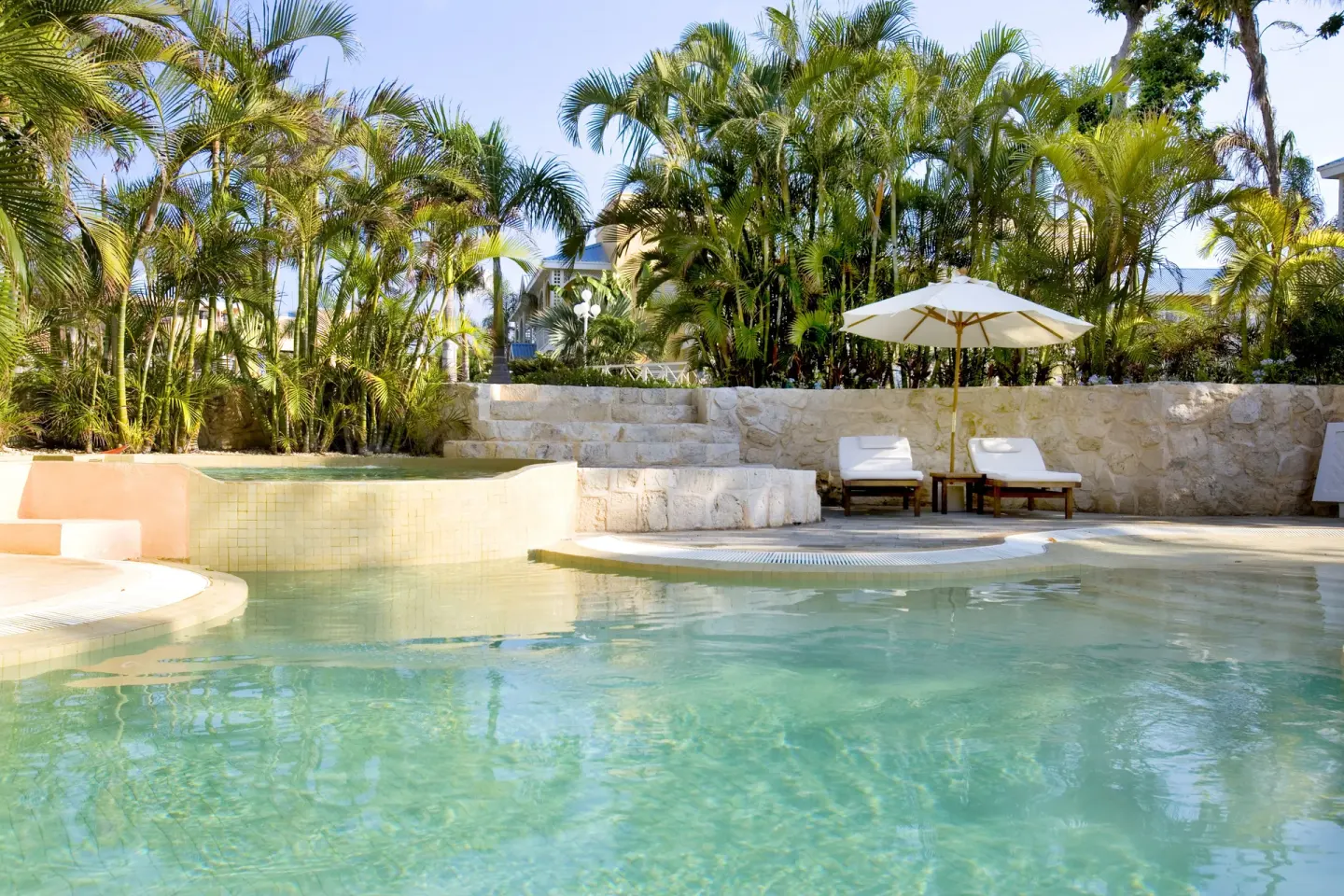 Quiet garden pool with umbrella-shaded loungers at Royal Hideaway Playacar.