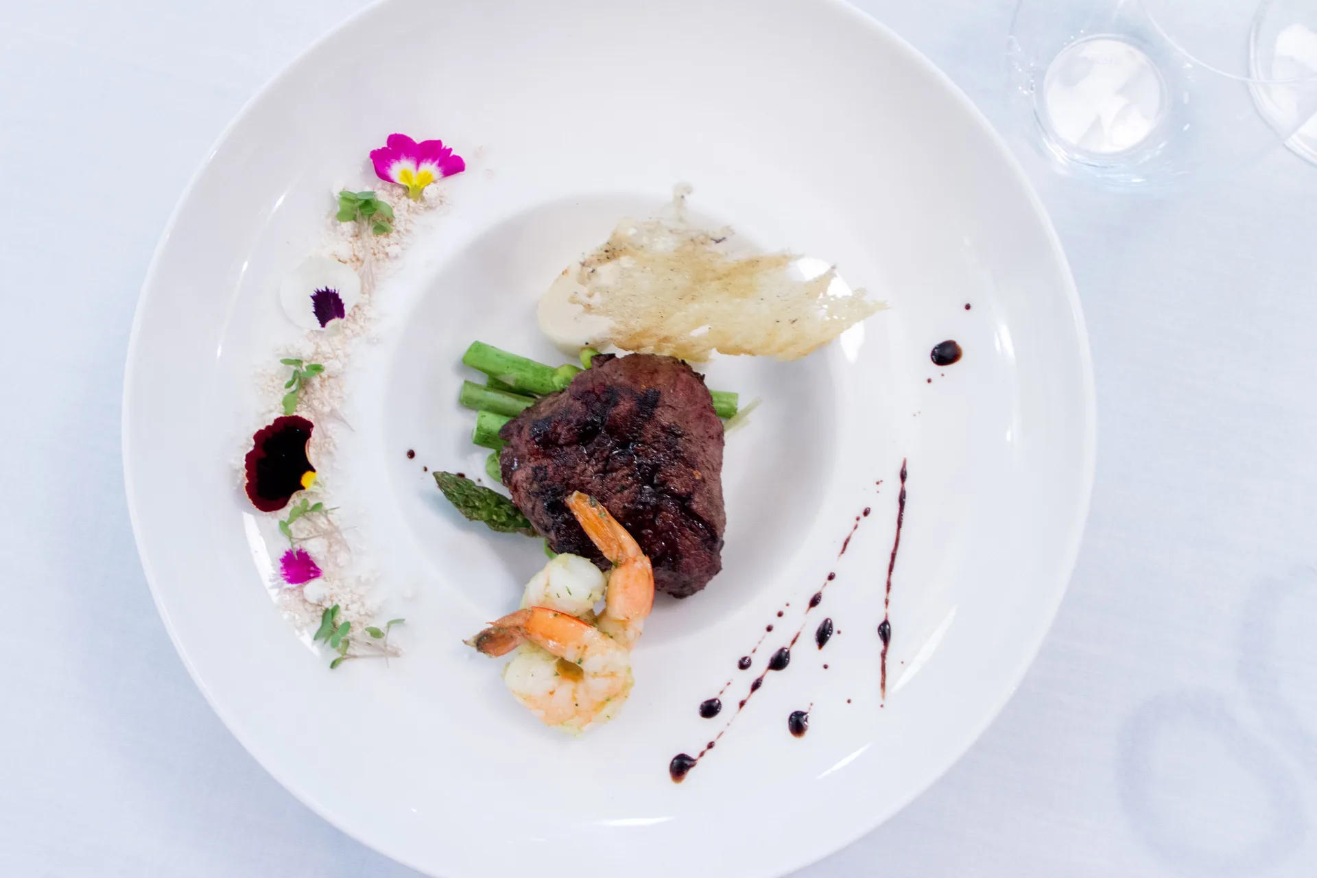 Plated steak and shrimp entrée with asparagus at Royal Hideaway Playacar.