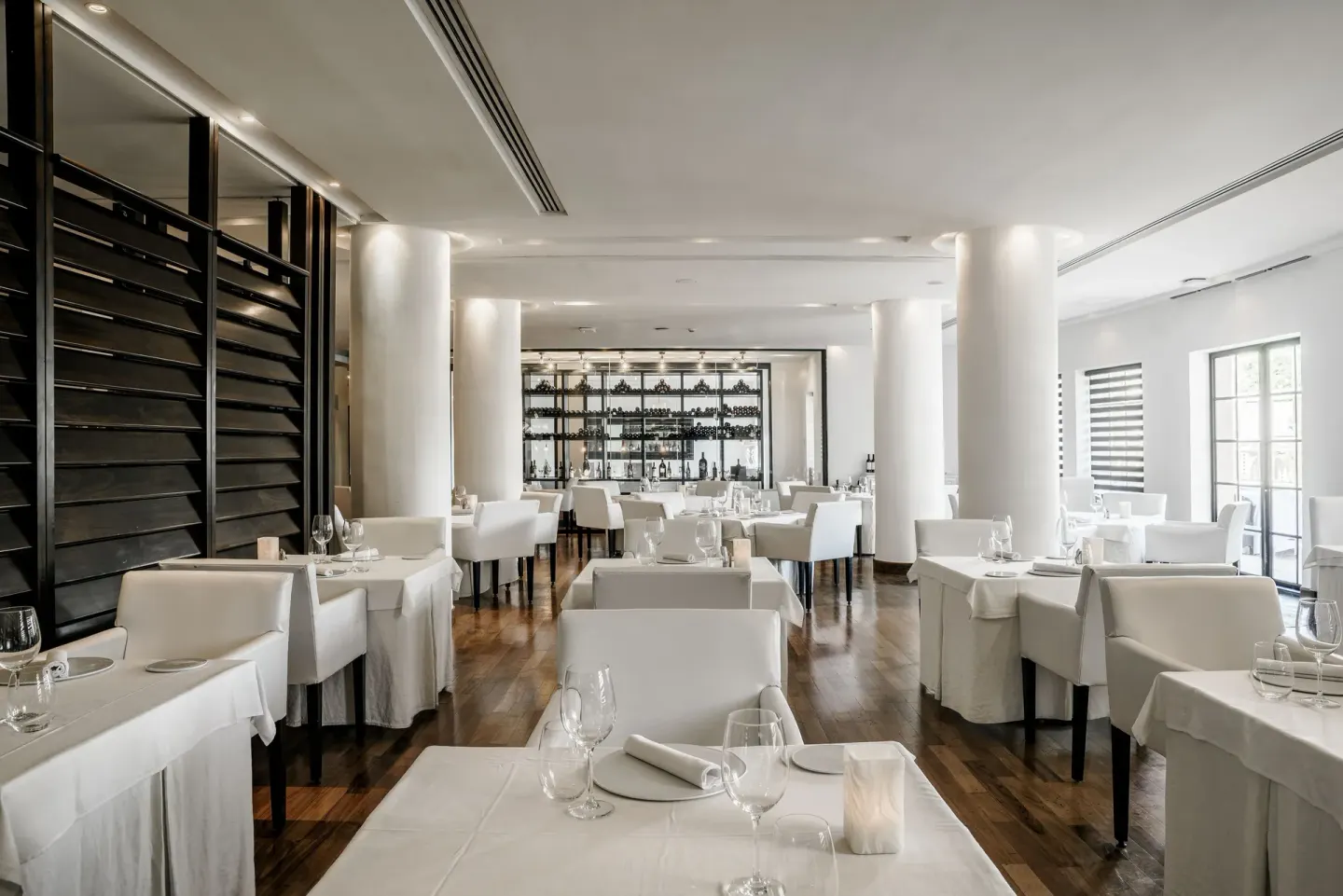 White-tablecloth dining room with wine display at Royal Hideaway Playacar.