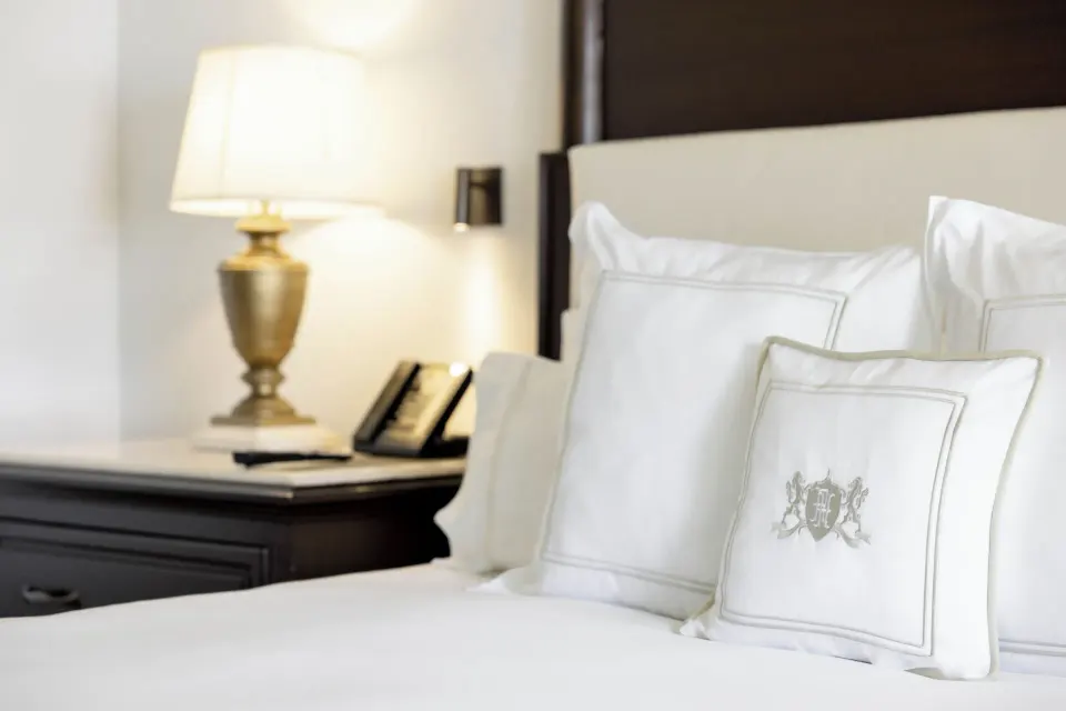 Luxury Room king bed pillows and bedside lamp at Royal Hideaway Playacar.
