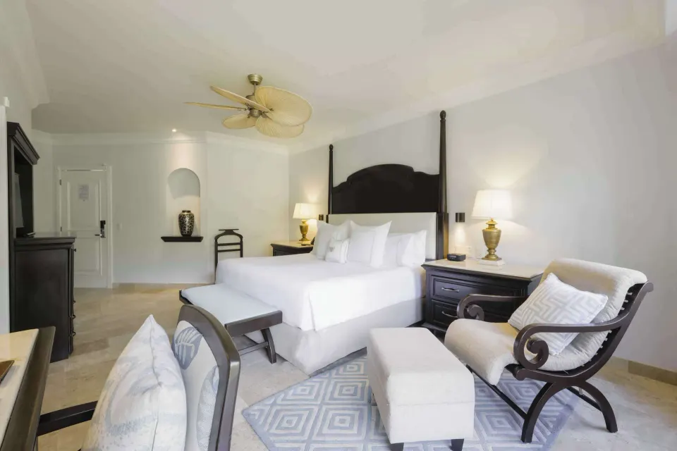 Luxury Room with king bed and seating area at Royal Hideaway Playacar.
