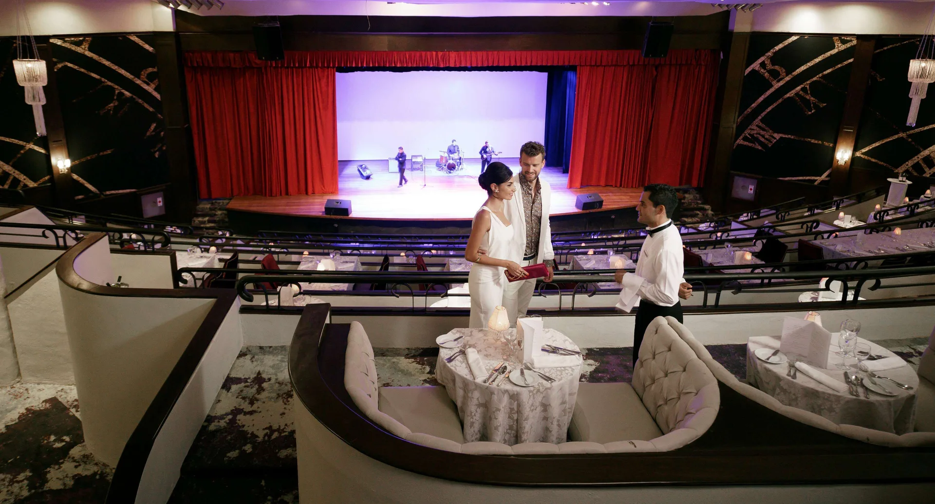 Couple being served at a theater dining table at Royal Hideaway Playacar.