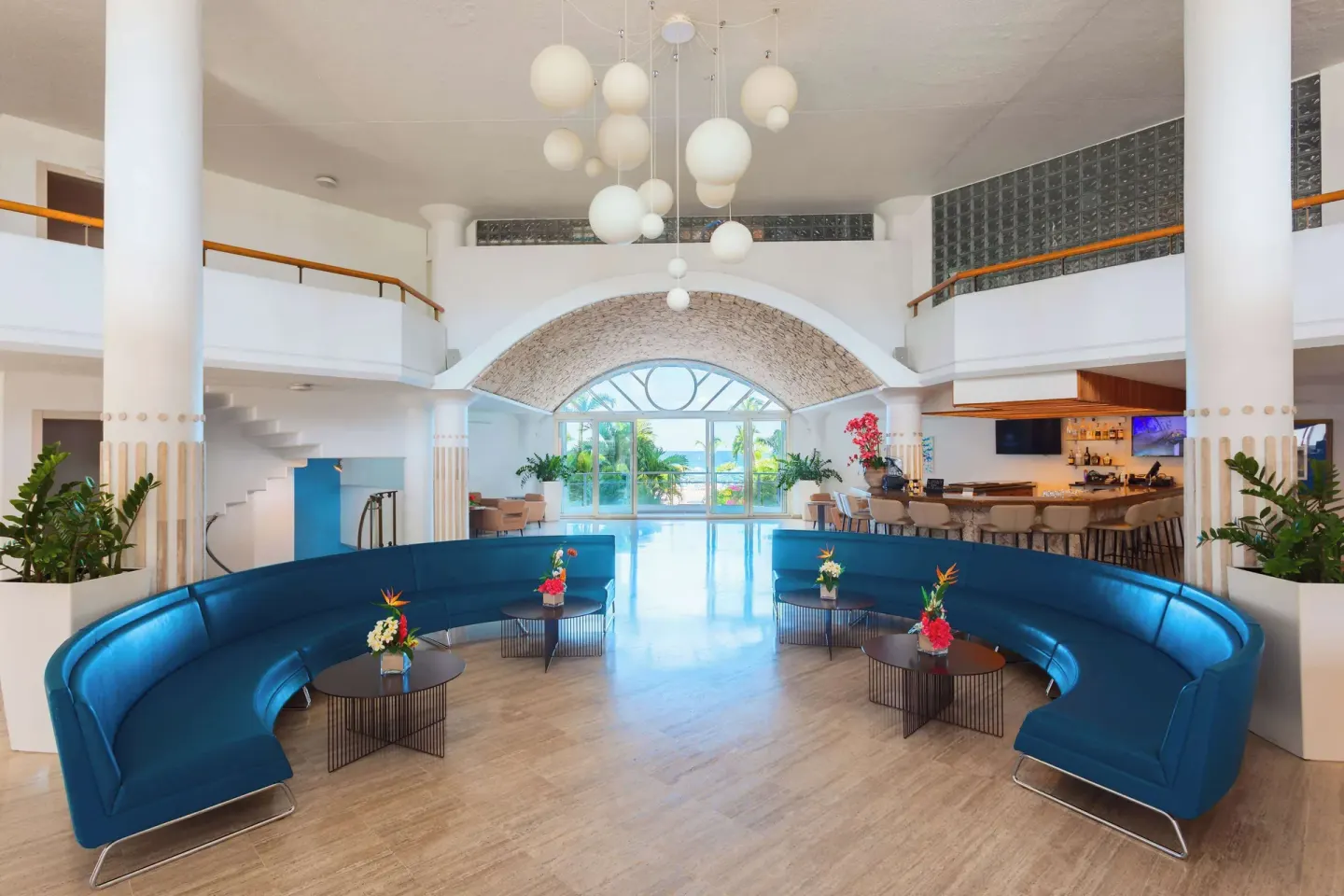 Bright lobby with blue seating and arched windows at Royal Islander Resort La Plage.