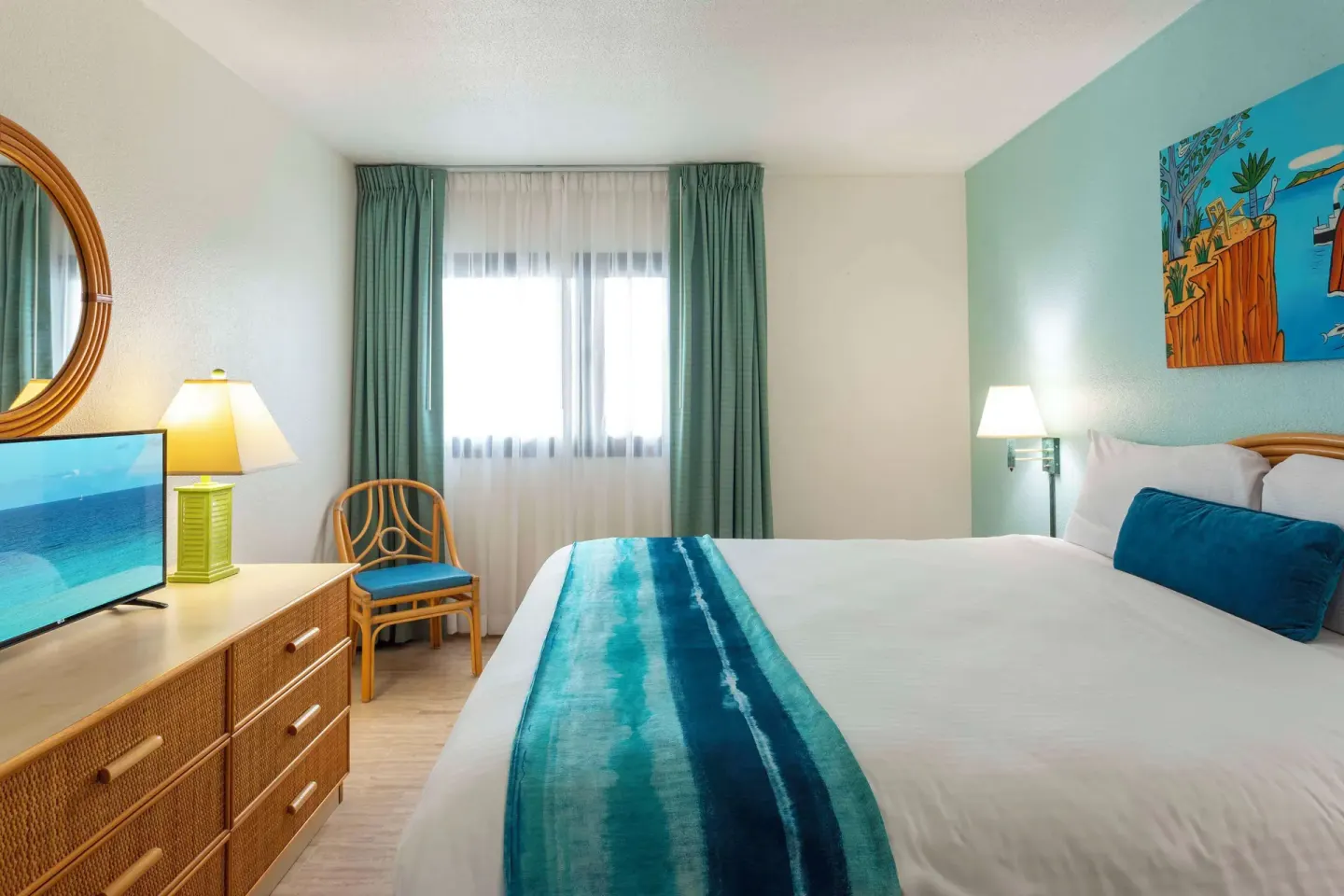 King bed guest room with turquoise accents at Royal Islander Resort La Plage.
