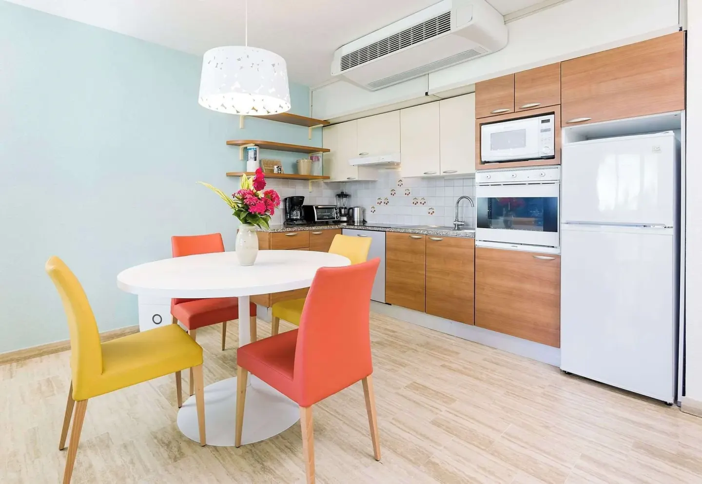 Guest room kitchen with round dining table at Royal Islander Resort La Plage.