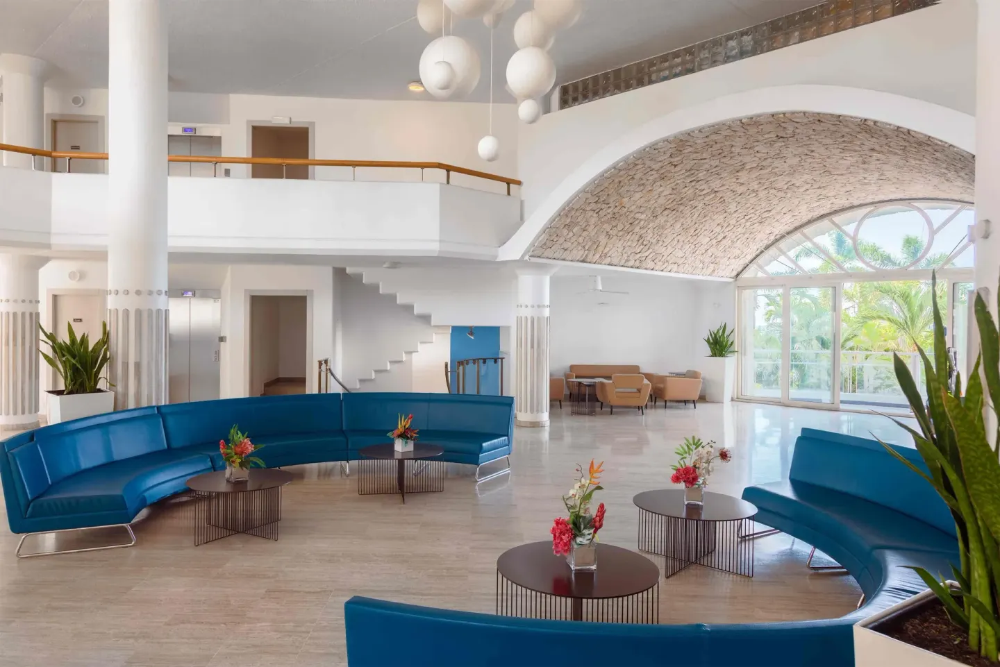 Lobby seating with blue sofas and arched windows at Royal Islander Resort La Plage.