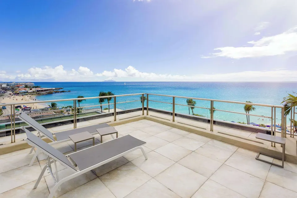 Oceanfront terrace with loungers overlooking the beach at Royal Islander Resort La Plage.