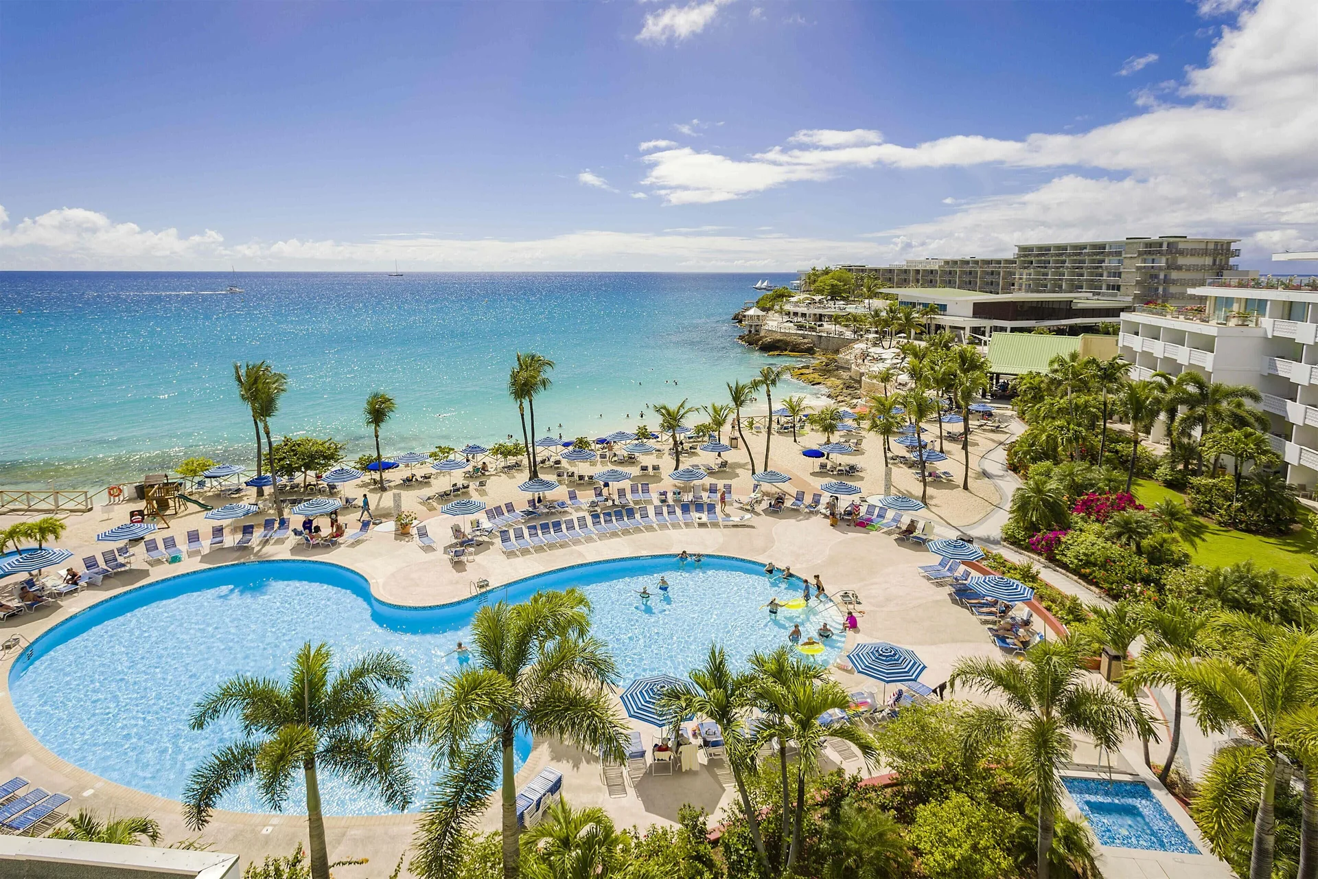 Pool, beach, and turquoise sea at Royal Islander Resort La Plage.