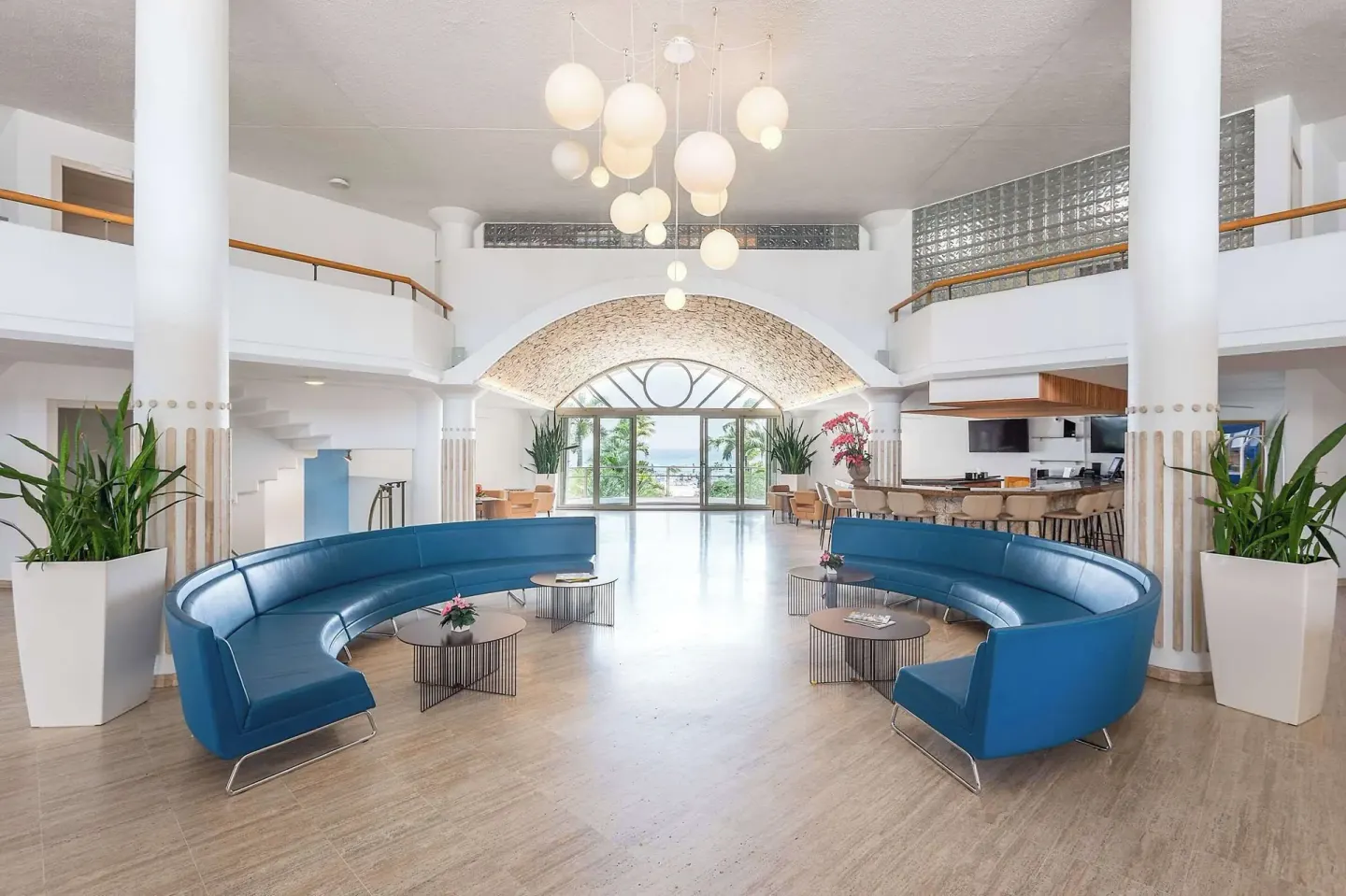 Spacious lobby with white columns and blue sofas at Royal Islander Resort La Plage.