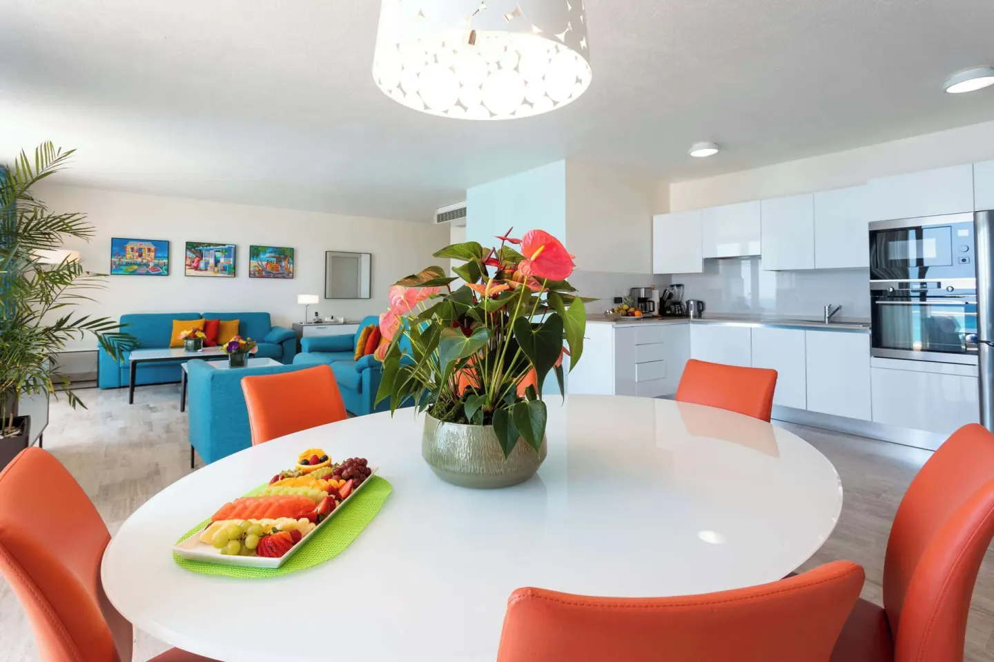 Open suite dining table, kitchen, and lounge at Royal Islander Resort La Plage.