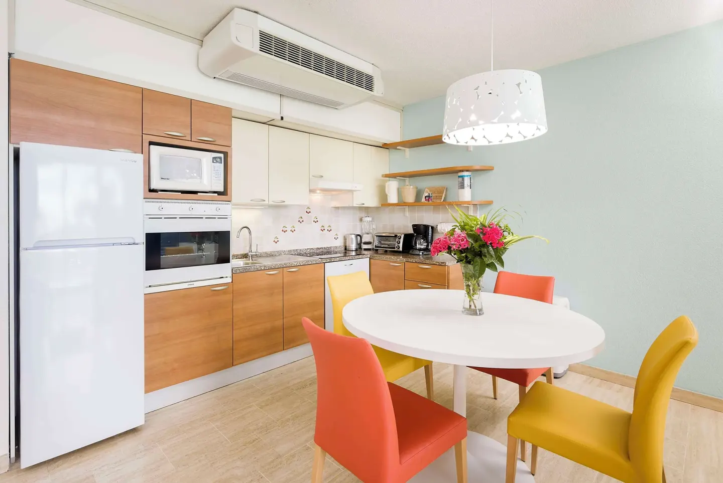 Compact suite kitchen and round dining table at Royal Islander Resort La Plage.