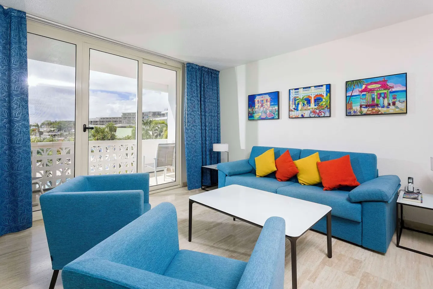Blue sofa seating area with balcony doors at Royal Islander Resort La Plage.