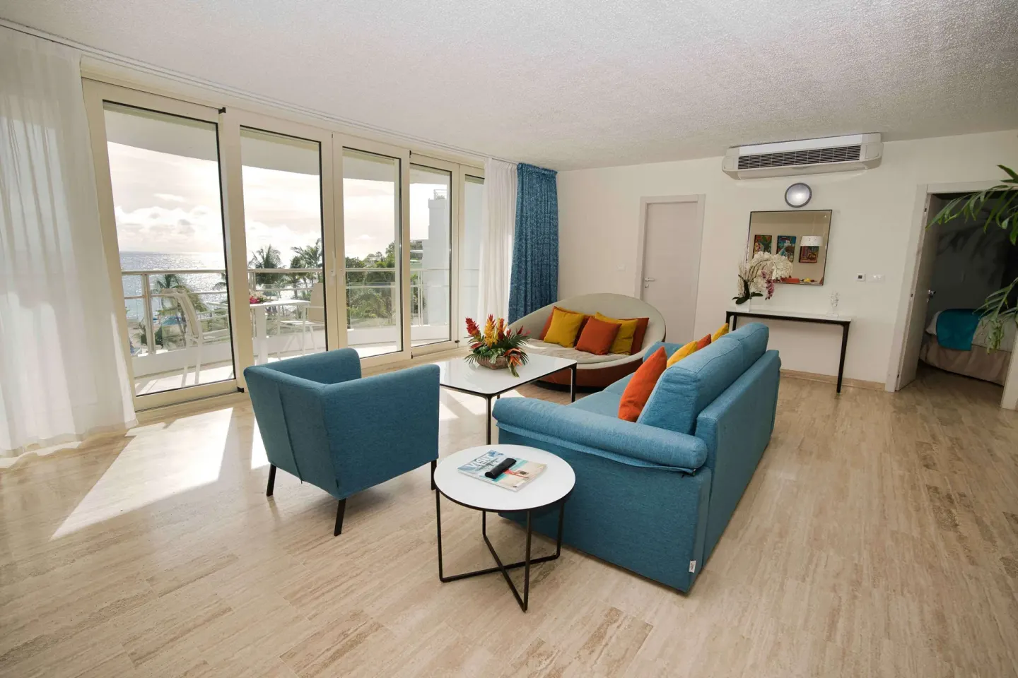 Spacious suite living area with balcony and ocean view at Royal Islander Resort La Plage.