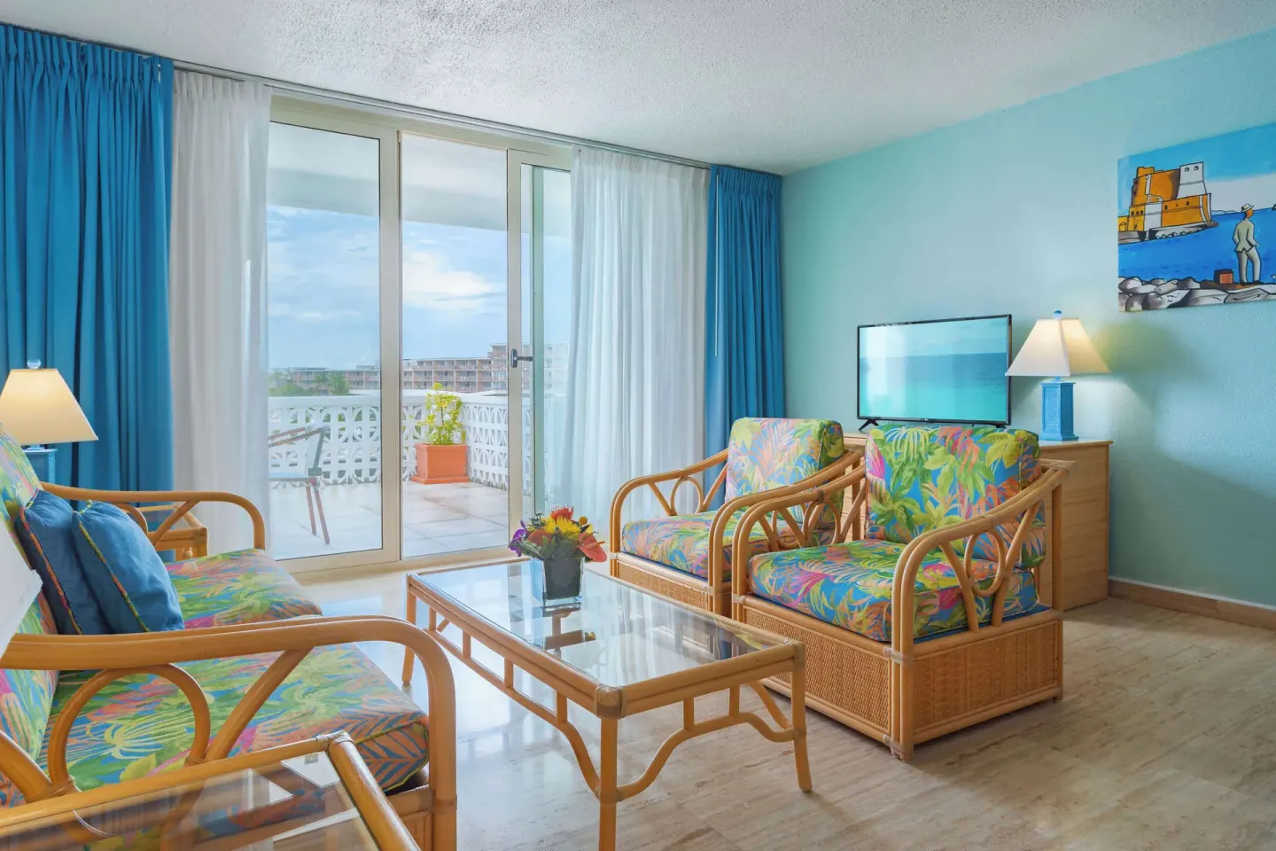 Living room with rattan seating and balcony doors at Royal Islander Resort La Plage.
