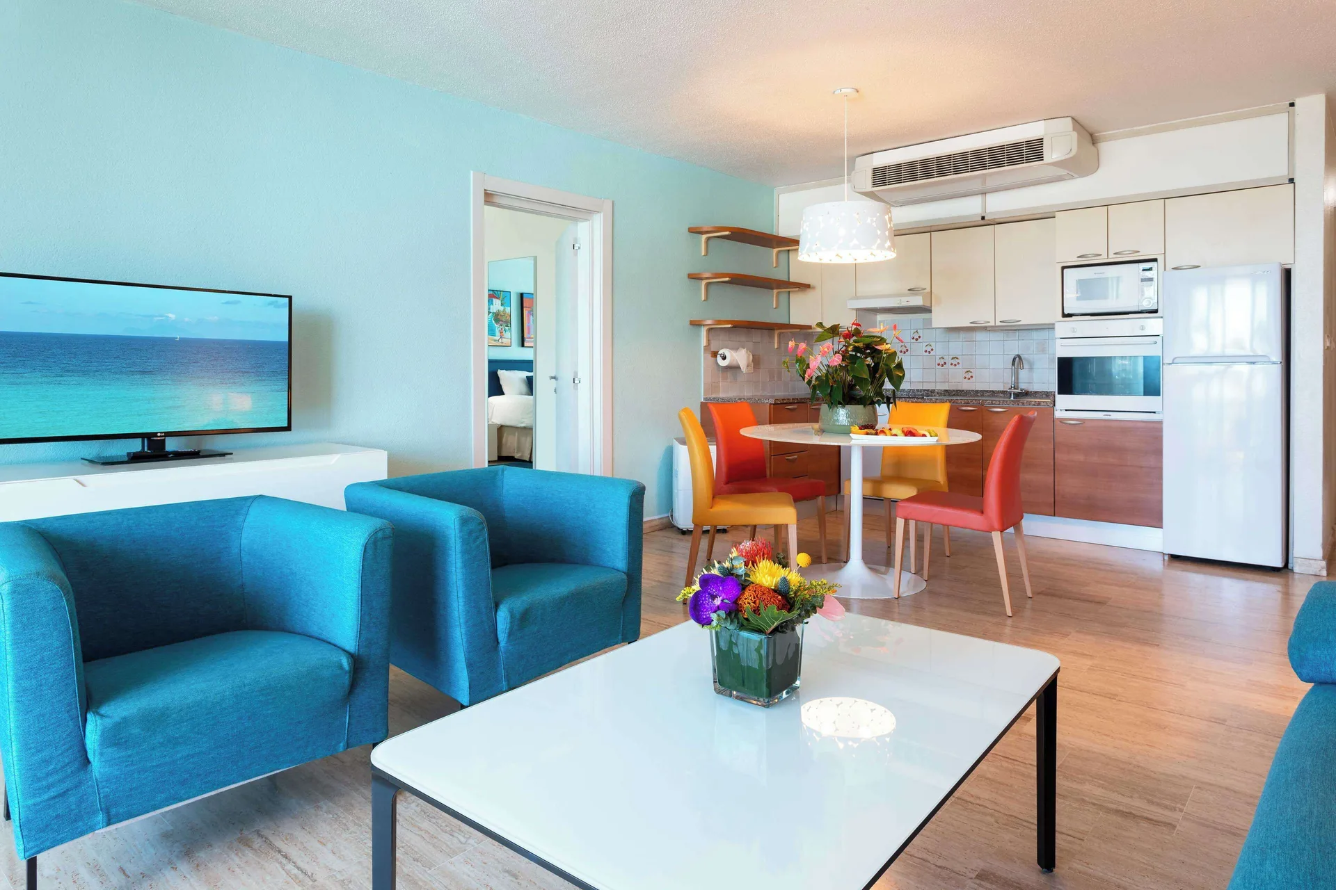 Living room with kitchen and dining table at Royal Islander Resort La Plage.