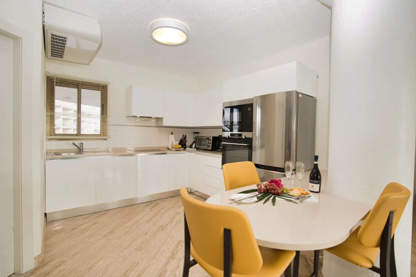 White guest room kitchen and dining table at Royal Islander Resort La Plage.