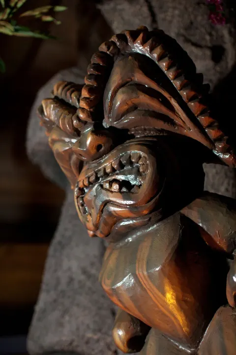 A carved wooden tiki figure is shown in close-up at Royal Kona Resort.