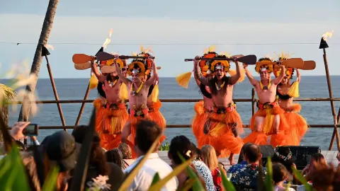 Performers hold paddles on an oceanfront stage at Royal Kona Resort.