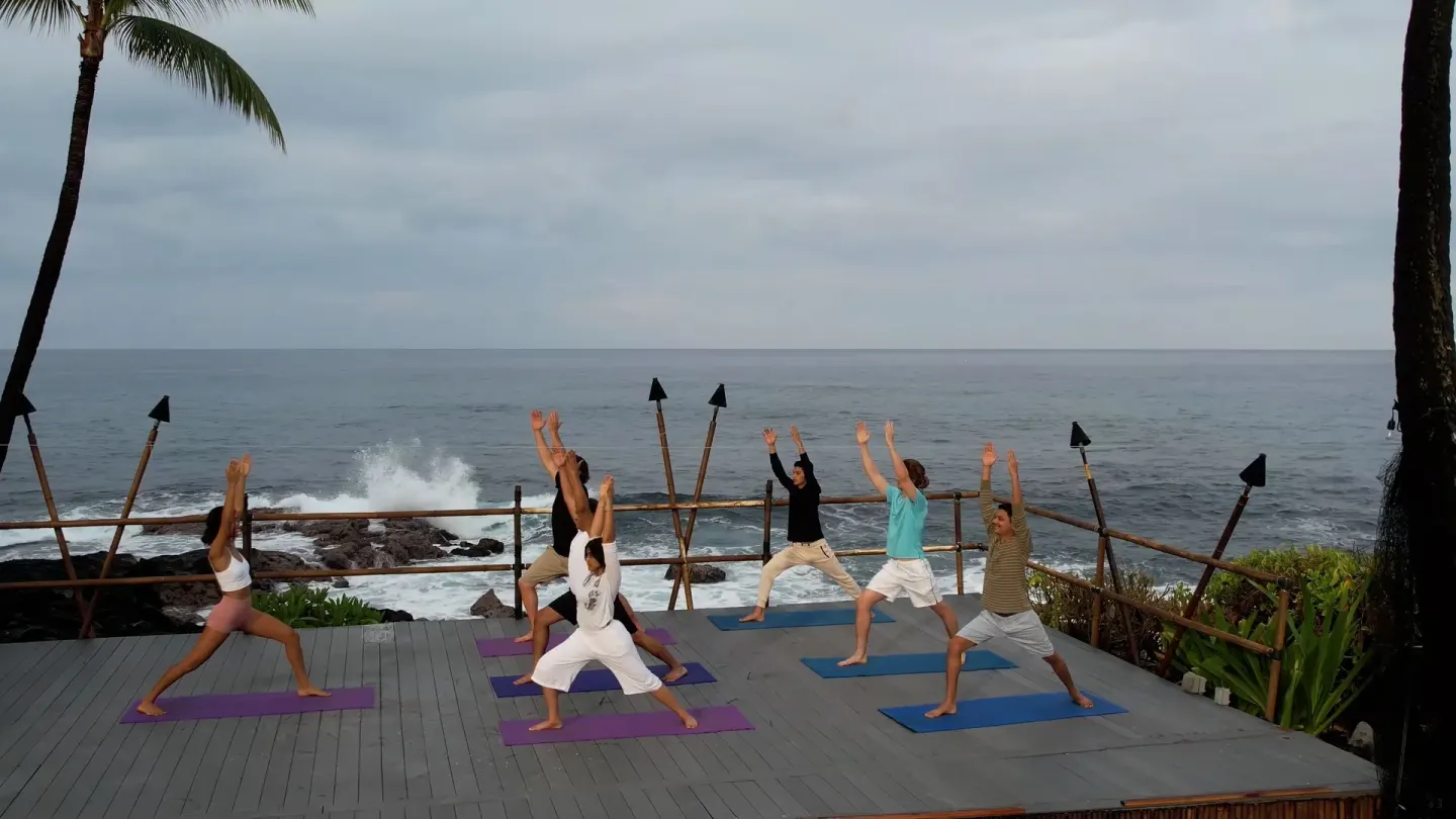 Outdoor yoga class on an oceanfront deck at Royal Kona Resort.