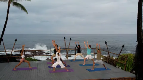 Outdoor yoga class on an oceanfront deck at Royal Kona Resort.