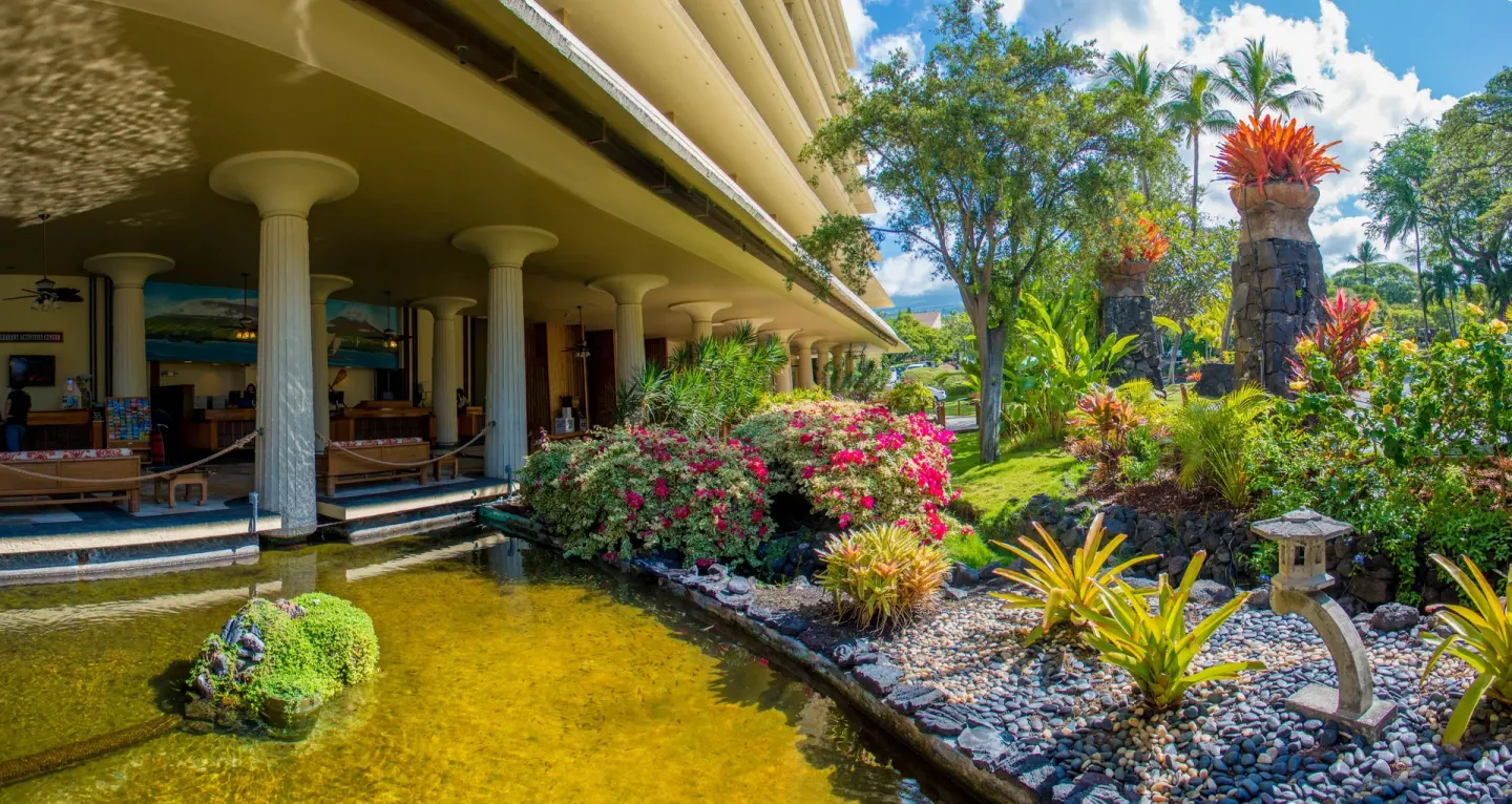 Tropical gardens and a lagoon sit beside open-air columns at Royal Kona Resort.
