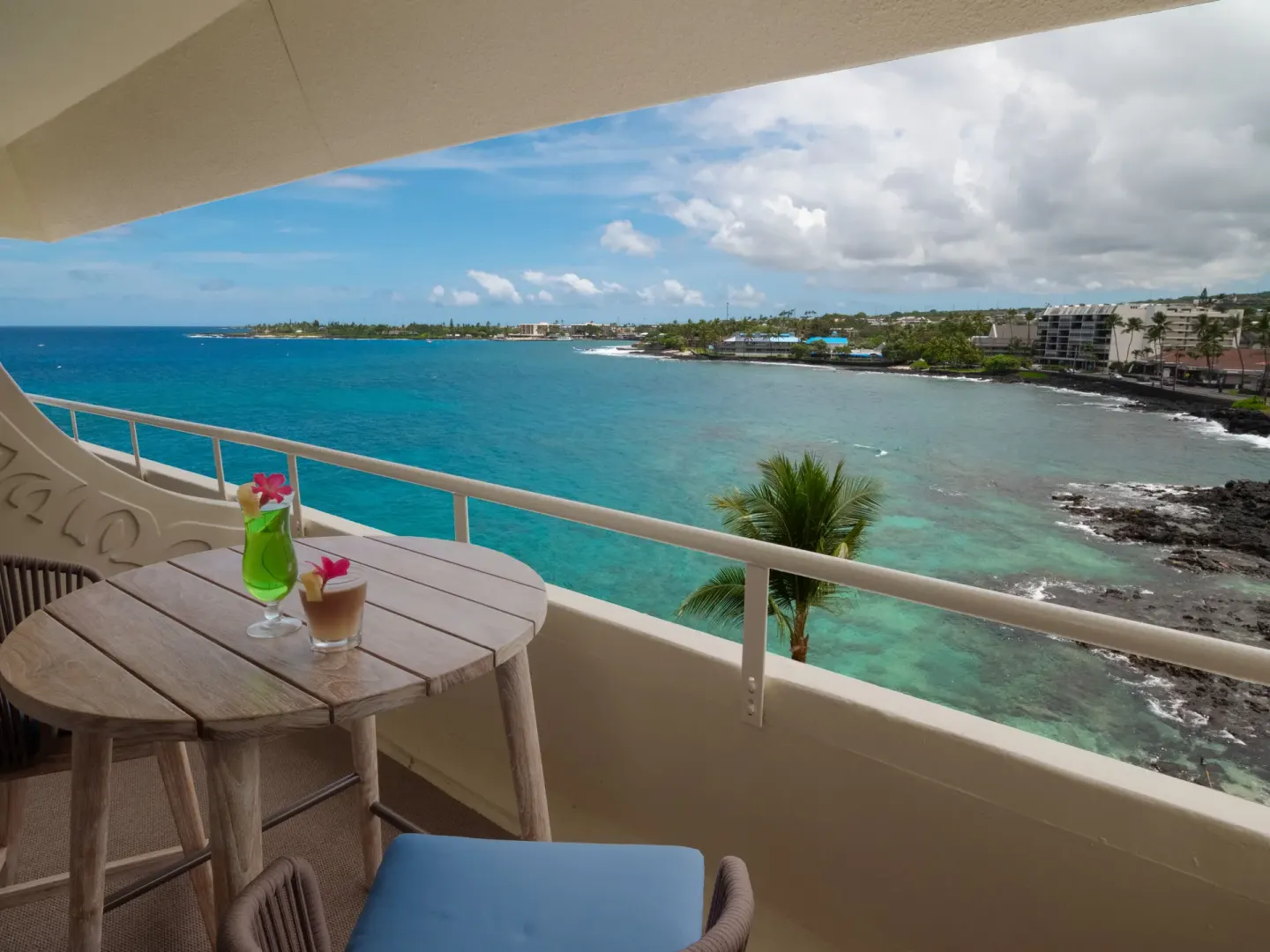 Ocean view balcony with table, drinks, and turquoise water at Royal Kona Resort.