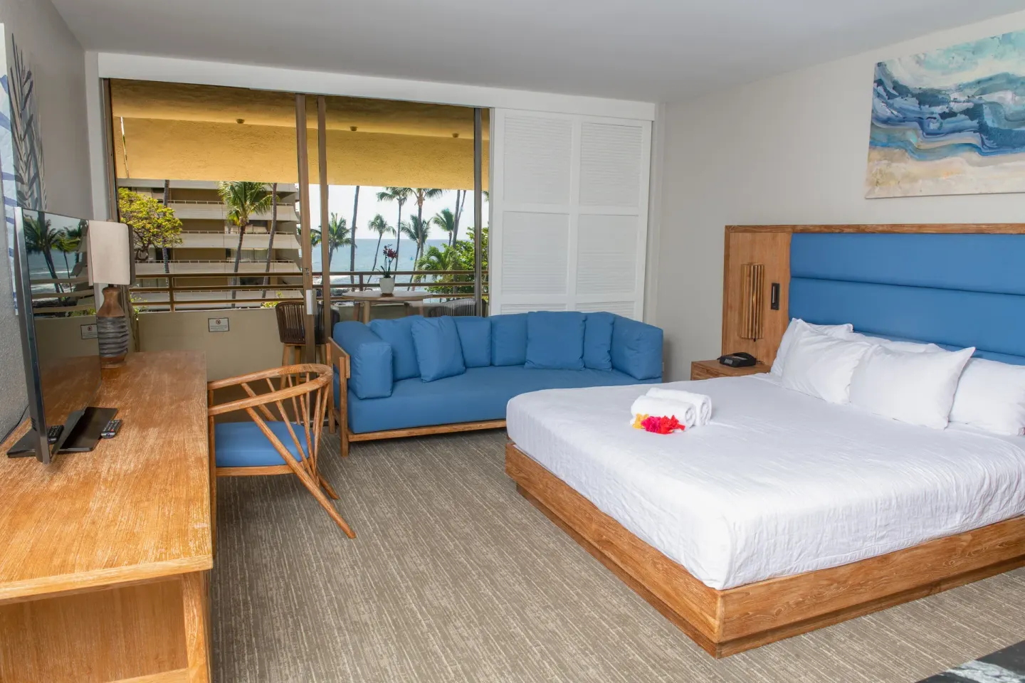 Partial ocean view king room with sofa and balcony at Royal Kona Resort.