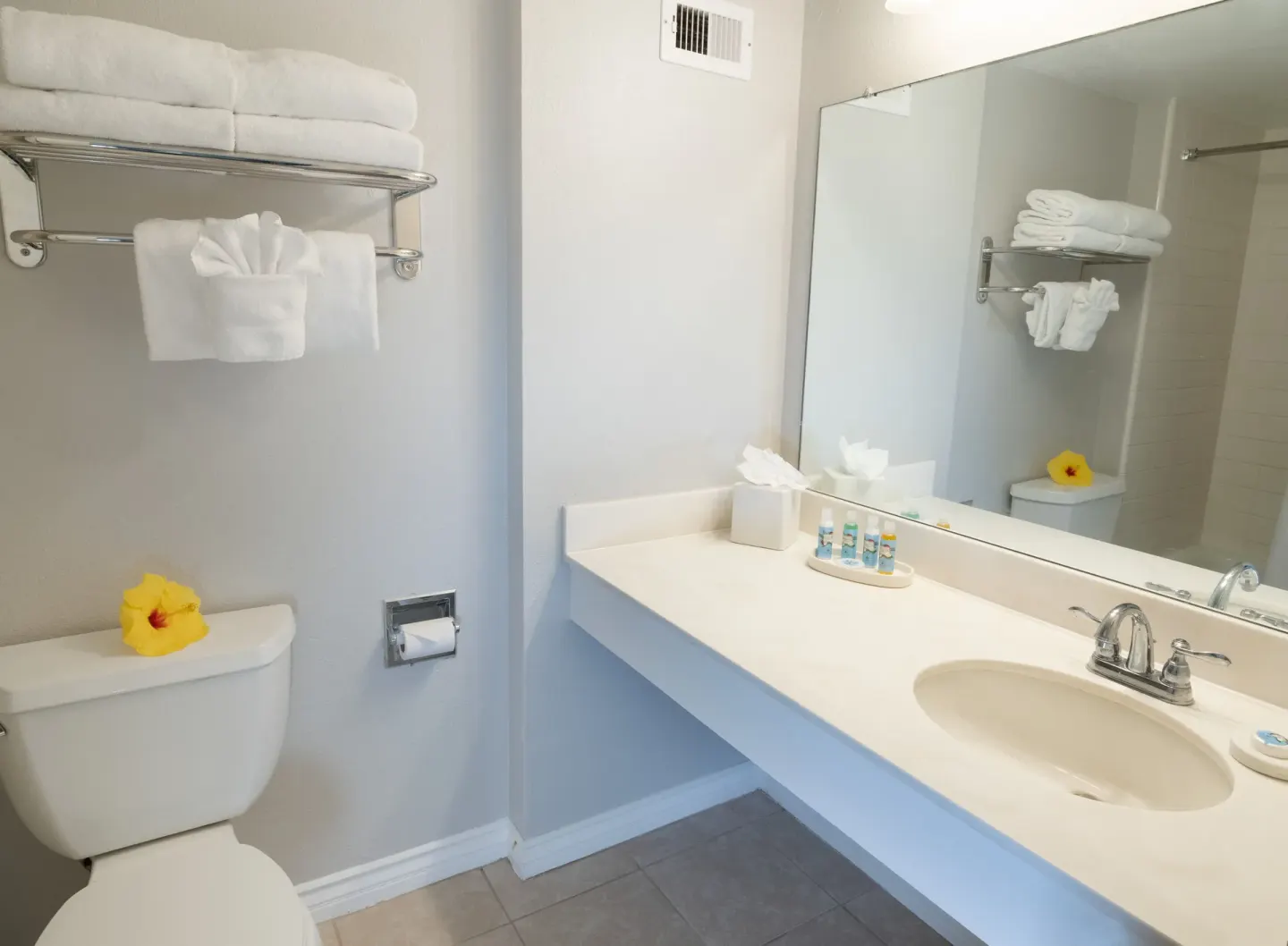 Standard room bathroom with vanity, mirror, towels, and tub area at Royal Kona Resort.
