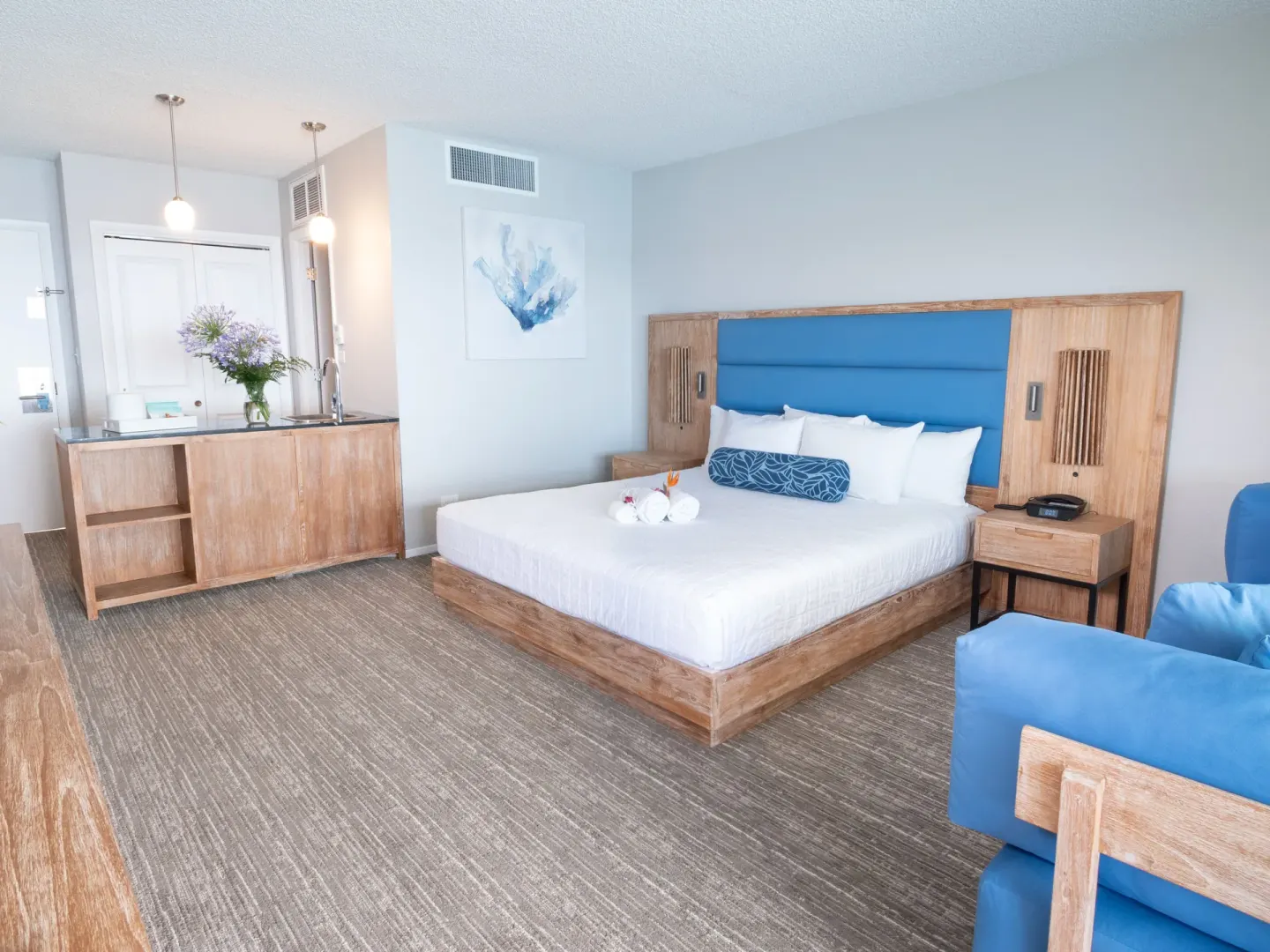 Standard room with king bed, blue headboard, and wet bar at Royal Kona Resort.
